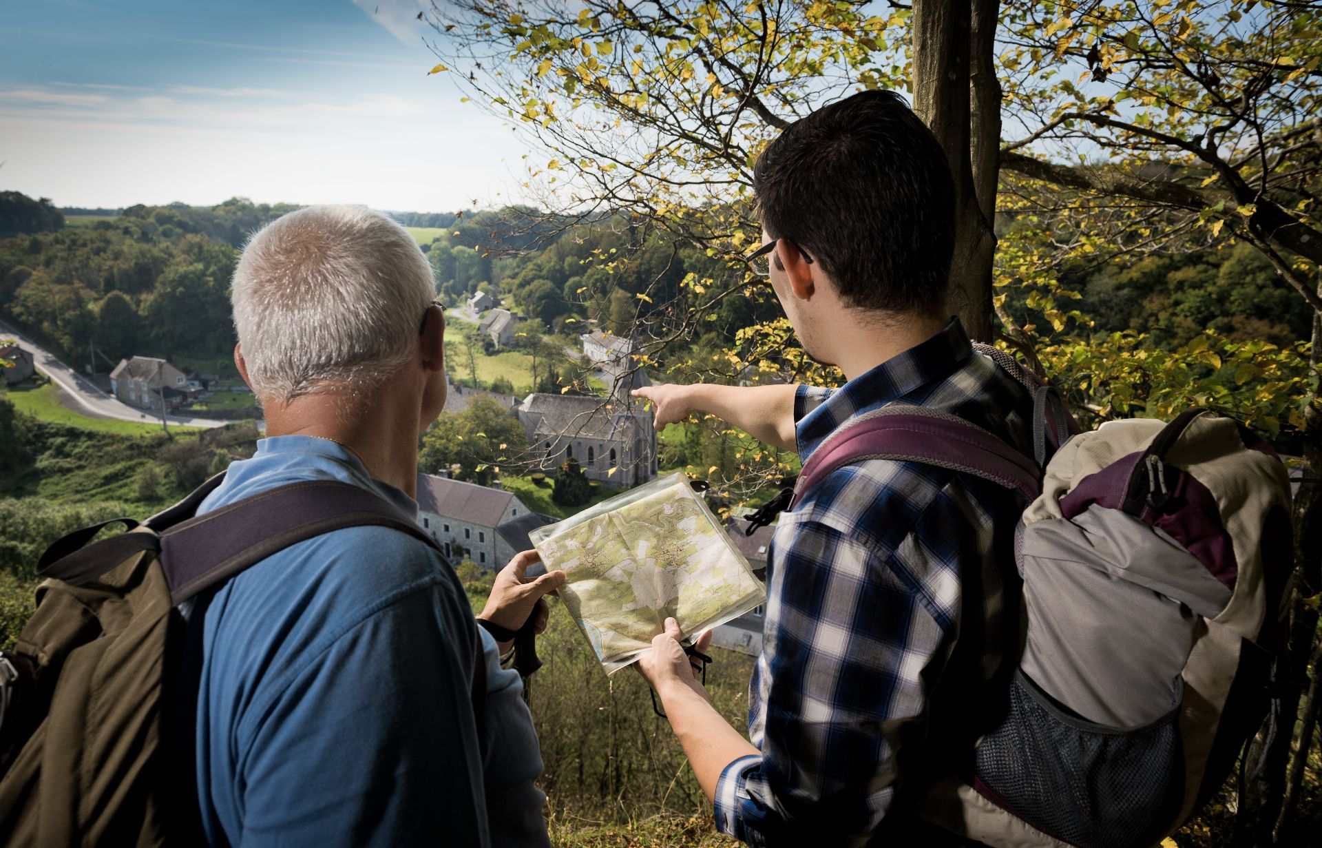 Twee wandelaars raadplegen een kaart en genieten van het uitzicht op het dorp Lompret