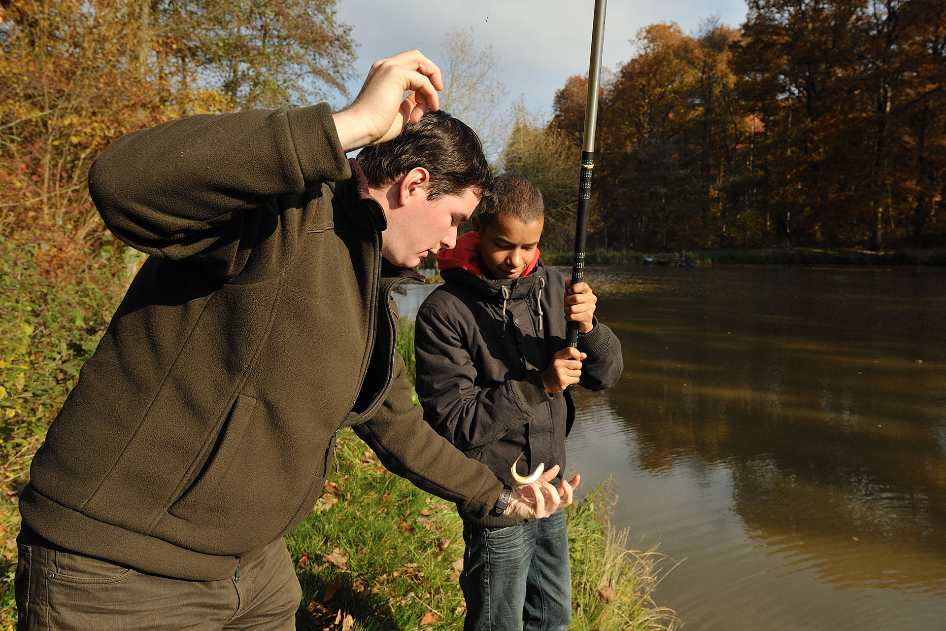 Un homme apprend à un enfant à pêcher au centre Riveo