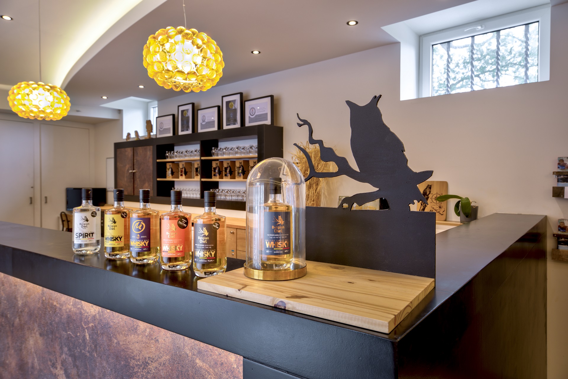Comptoir avec des bouteilles de whisky de la distillerie Belgian Owl