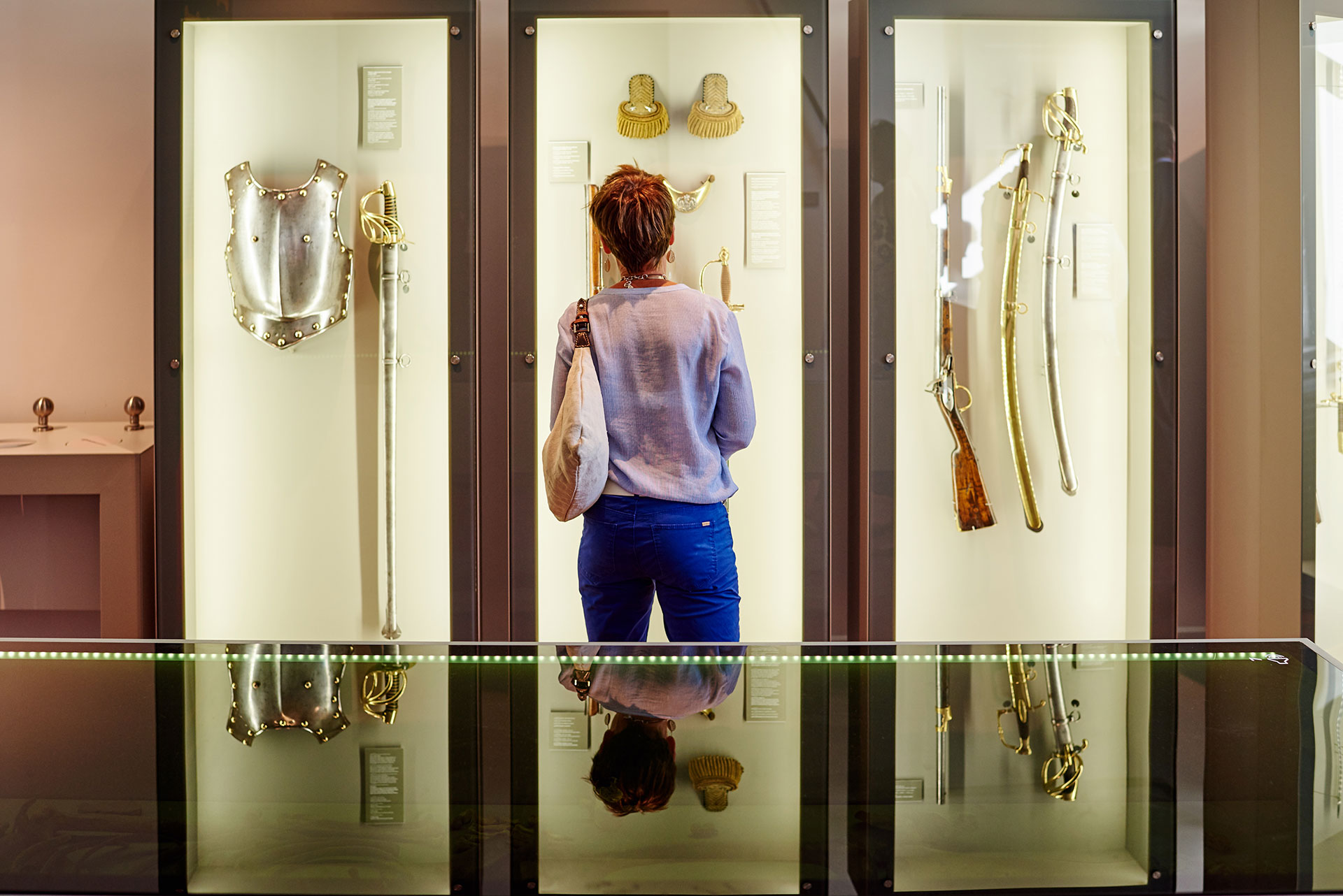 Femme se tenant debout devant une vitrine où sont exposés des objets authentiques de 1815