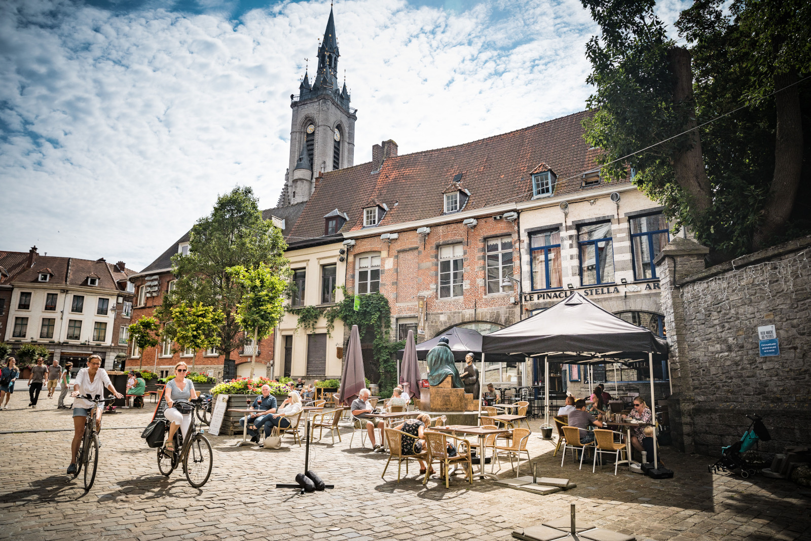 Tournai - rue du Vieux Marché, deux cyclistes près des brasseries animées.
