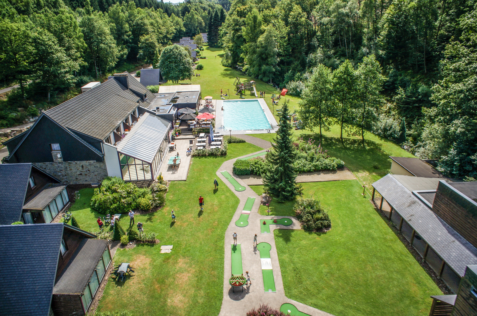 Aerial view of the buildings, the swimming pool and the infrastructures of the Val d'Arimont holiday village 