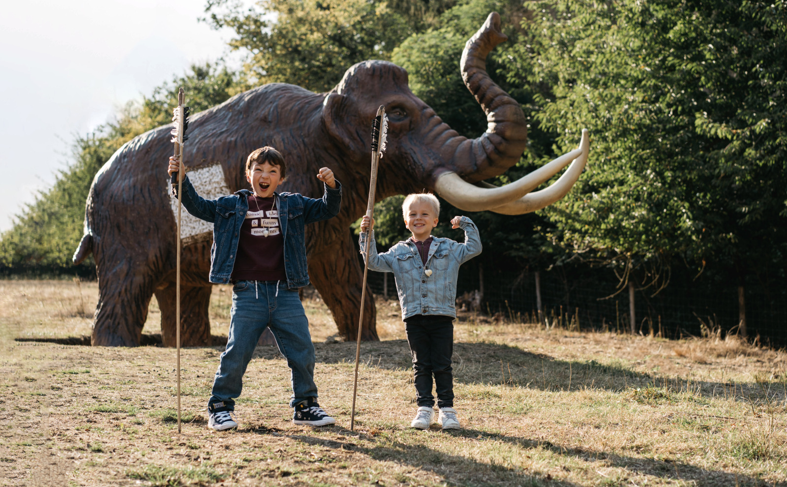 2 children with spears and a mammoth in the background at the Préhistomuseum in Flémalle