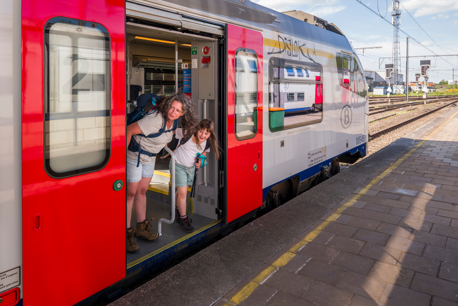 Une femme et sa fille descendent d'un train dans une gare en Wallonie