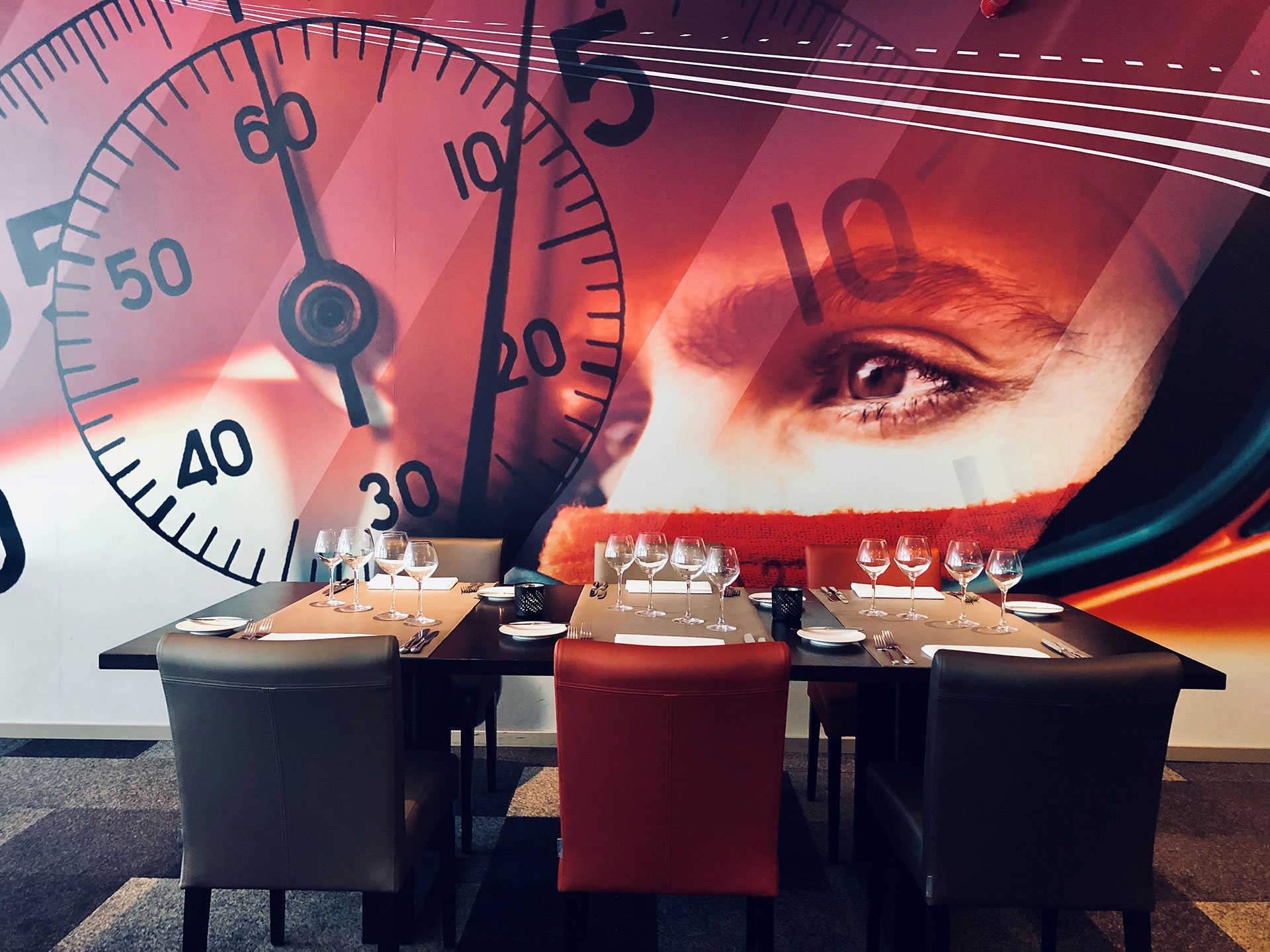 table de restaurant avec mur représentant un chrono et une personne avec casque