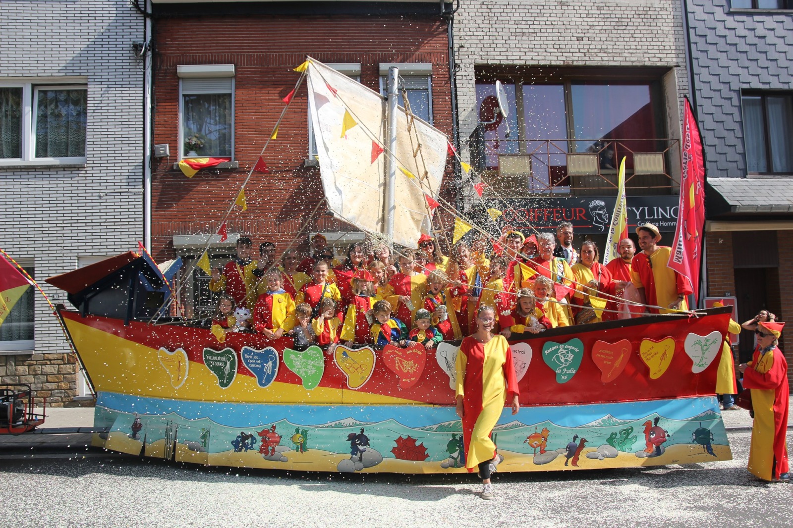 Char en forme de bateau à voile bien coloré avec un groupe d'enfants à son bord