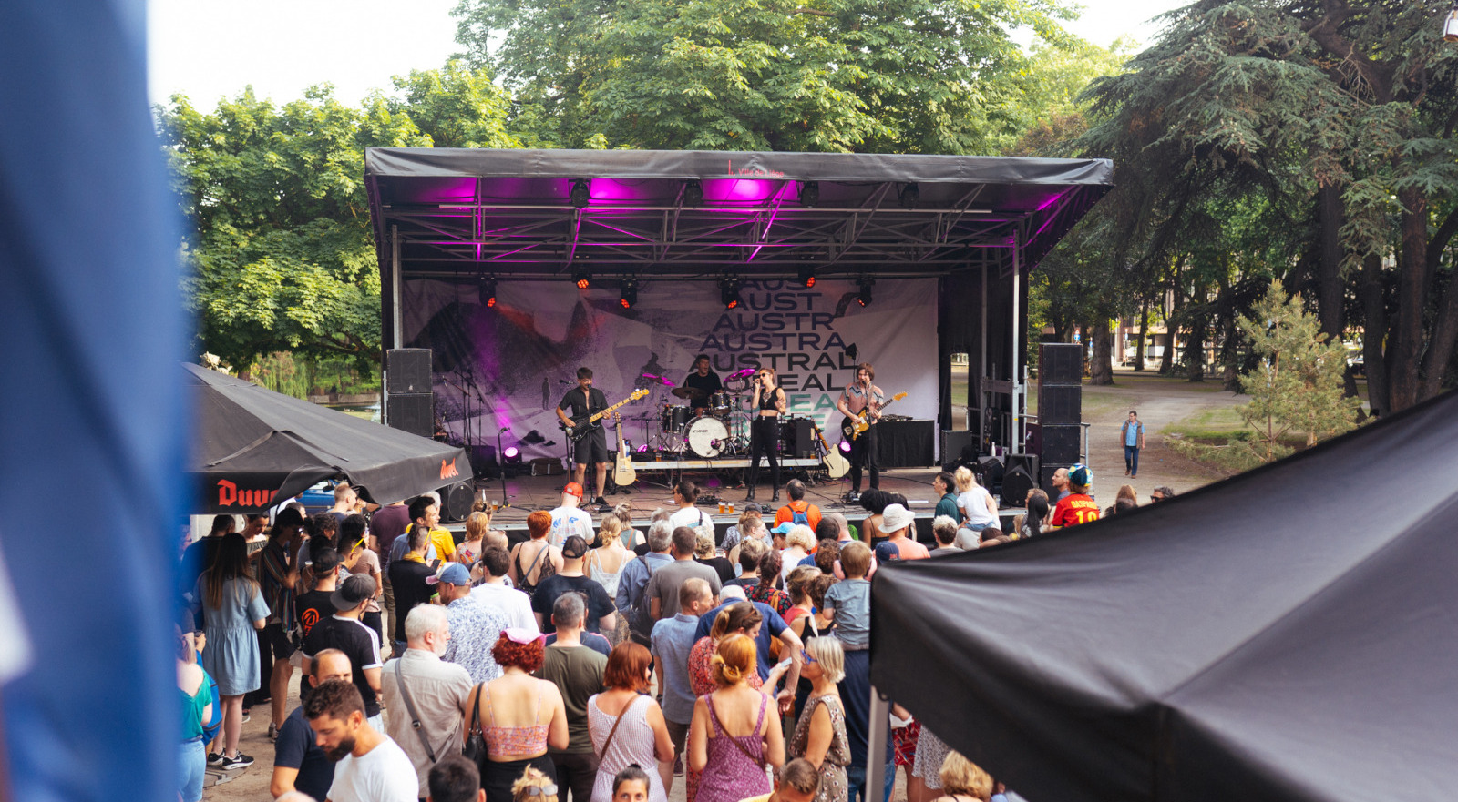 Musiciens se produisant sur une scène en plein air devant des festivaliers 