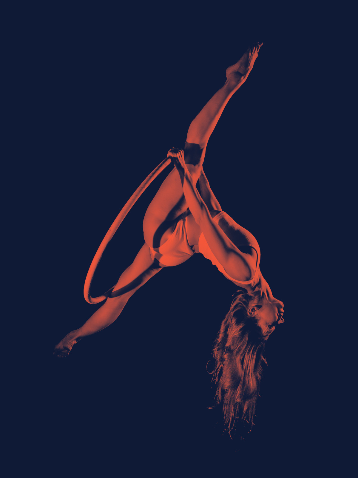 Femme trapéziste réalisant une acrobatie sur un cerceau