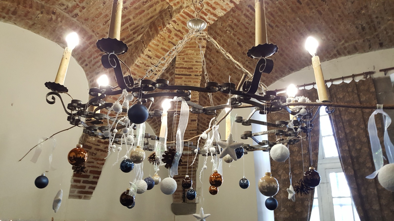 Lustre décoré de boules de Noël suspendu au plafond voûté 