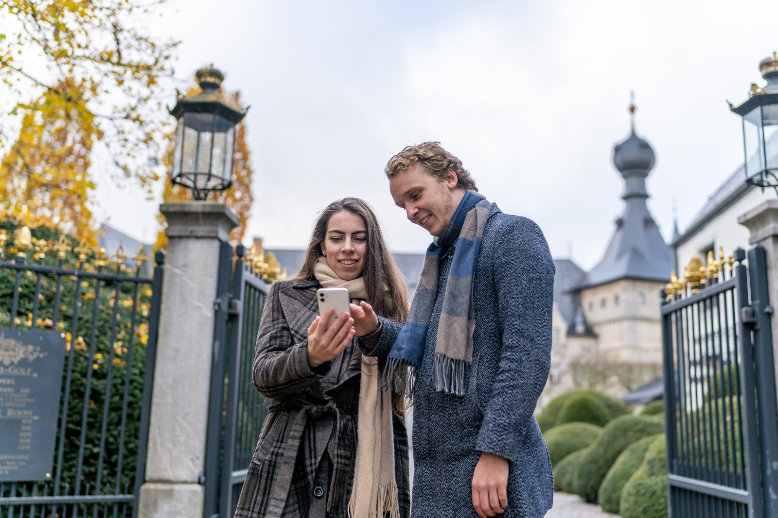 Un couple consulte en automne la web app du Pass sur son smartphone