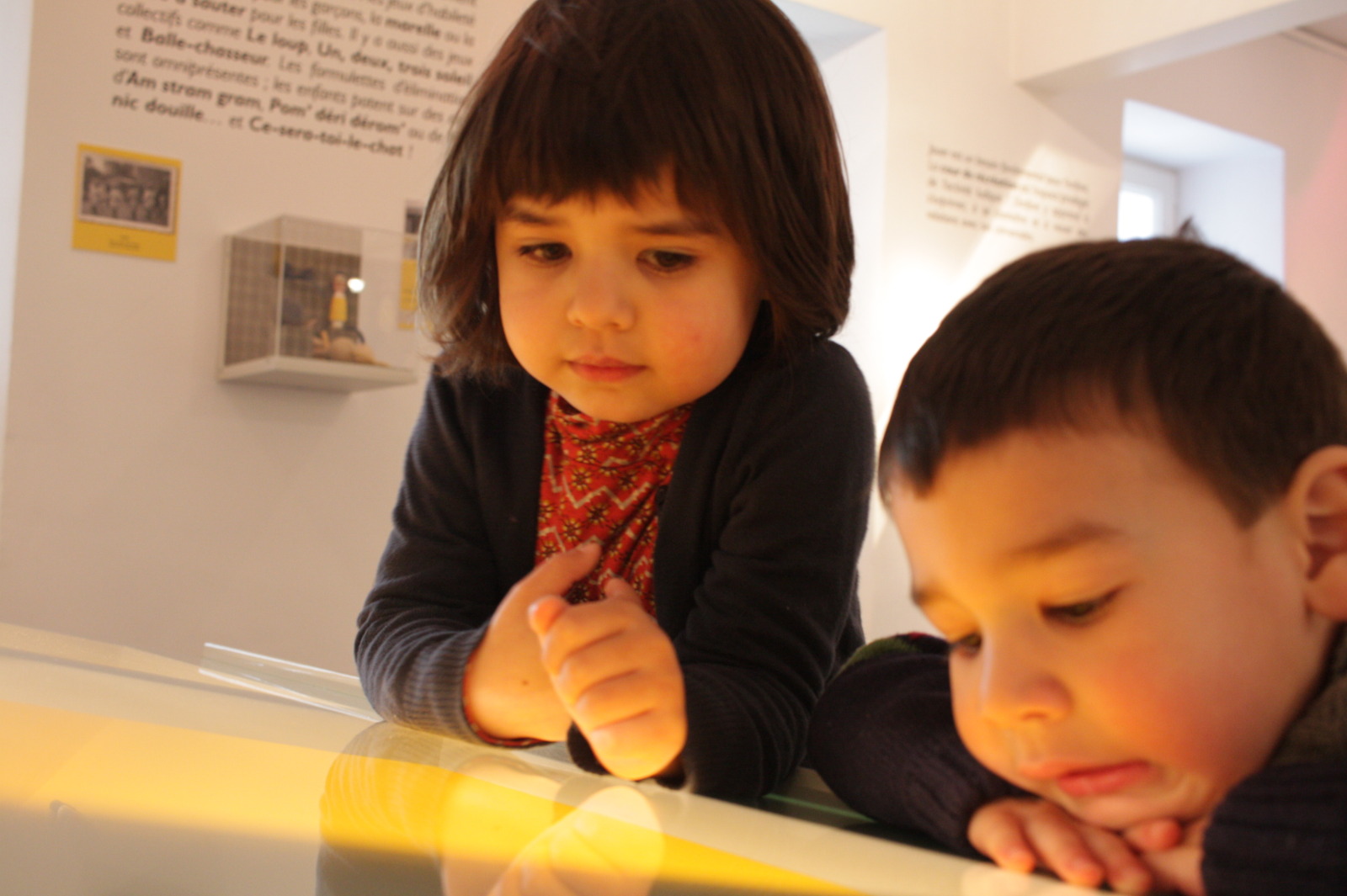 2 children look a lit panel at the Musée de la Grande Ardenne