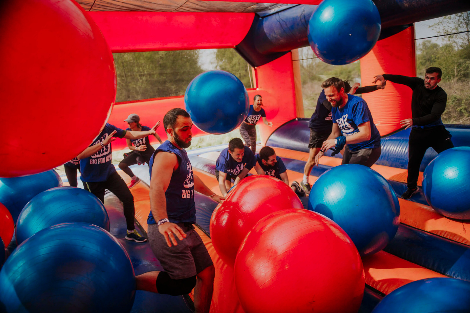 Obstacle gonflable rouge et bleu avec à l'intérieur de gros ballons