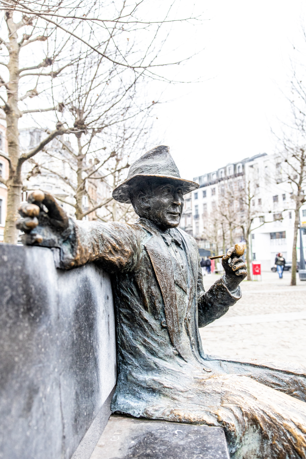 Hochformatfotografie der Statue von Georges Simenon, die sich in Lüttich auf der Place Saint-Lambert befindet.