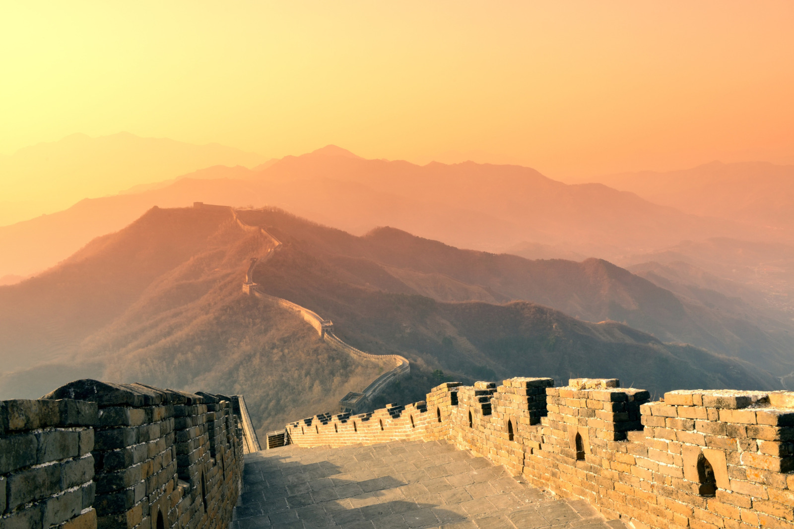 Photo de la muraille de Chine sous un soleil couchant.
