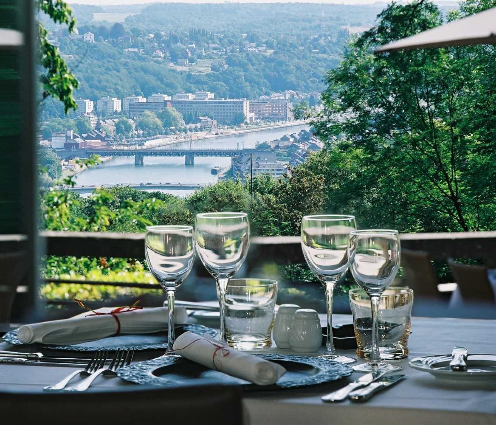 Panorama de Namur - Vue sur la Meuse d'une table de restaurant - verres, assiettes et couverts.