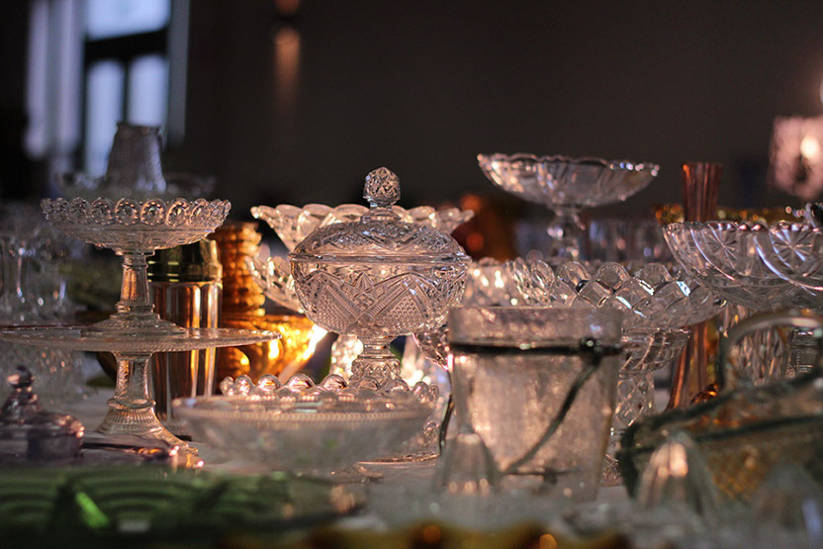 Foto van verschillende stukken glas en kristal geplaatst op een witte tafel.