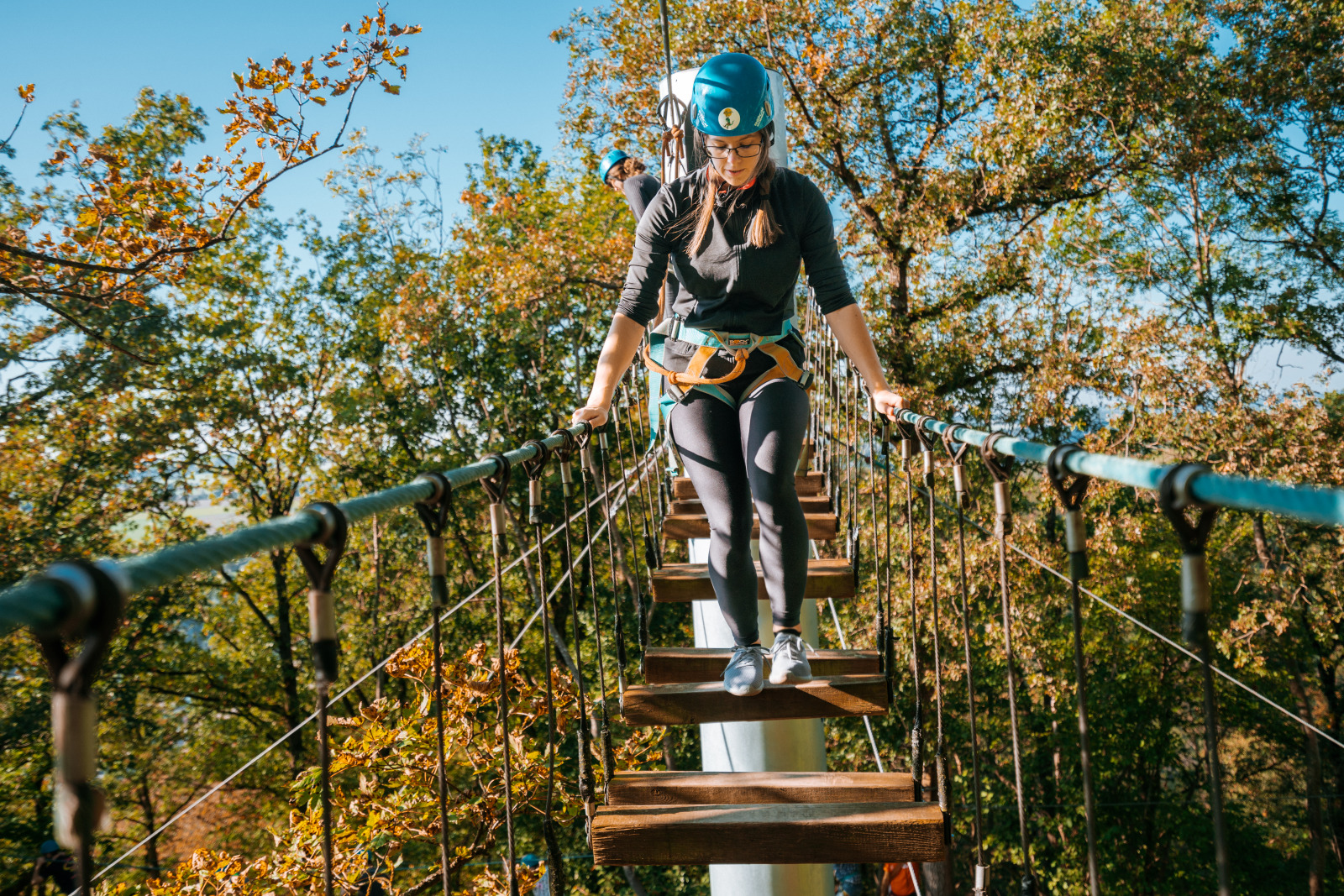 Woman crossing a rope bridge at Dinant Parc Aventure