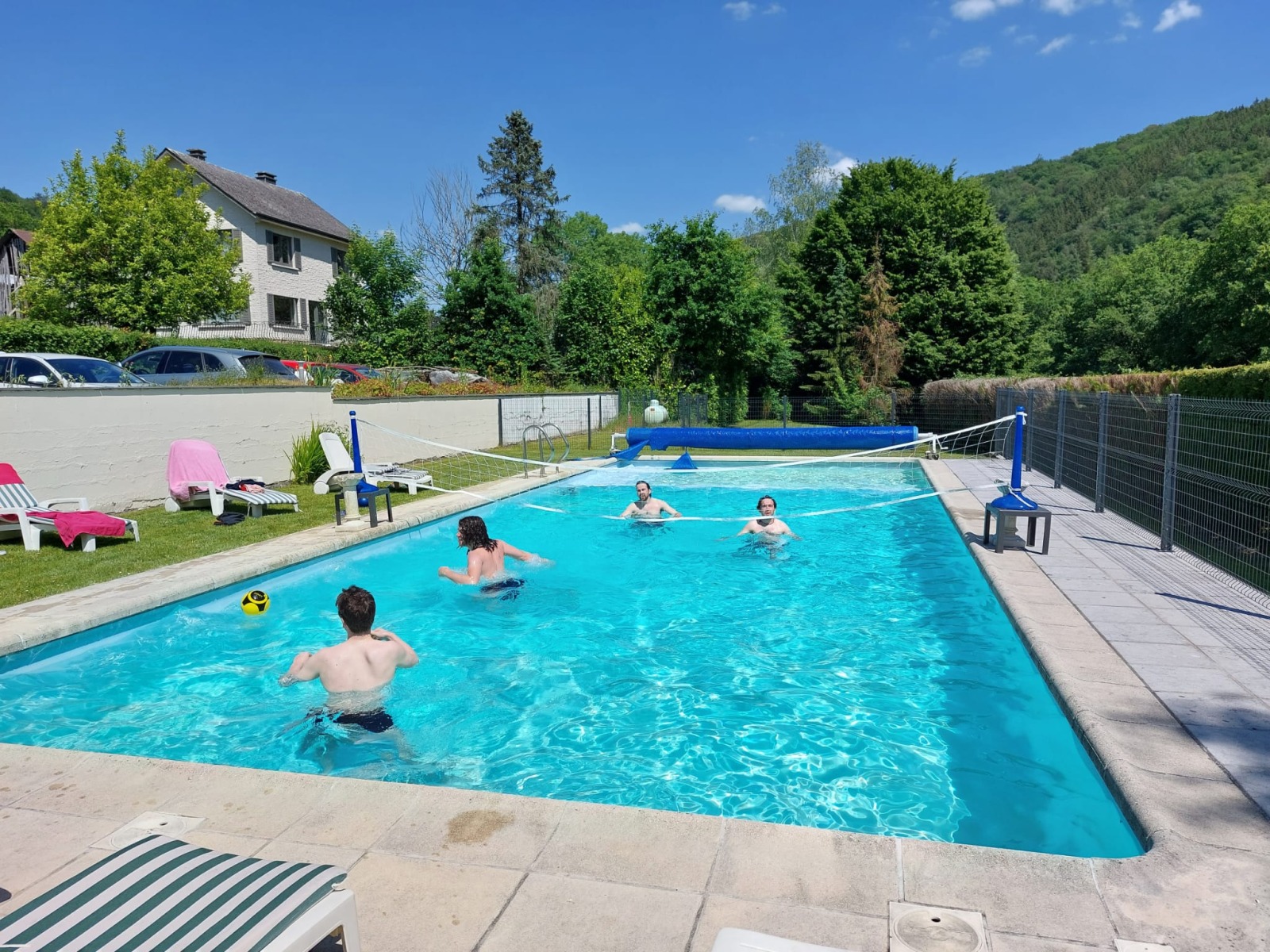 Vrienden die zich amuseren in het zwembad van Hotel Auberge Le Vieux Moulin in Poupehan