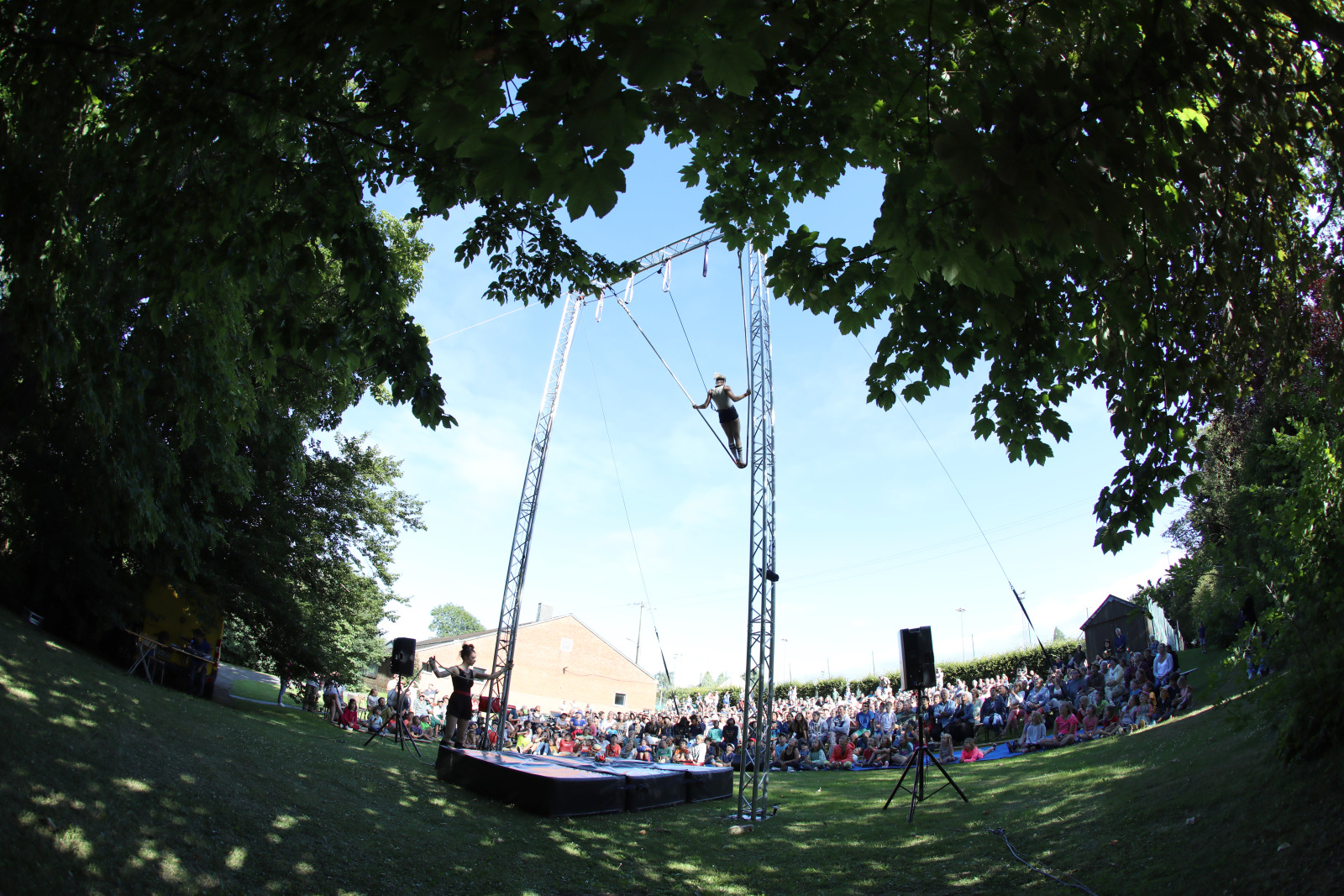 Trapeze artist performing acrobatics above the audience