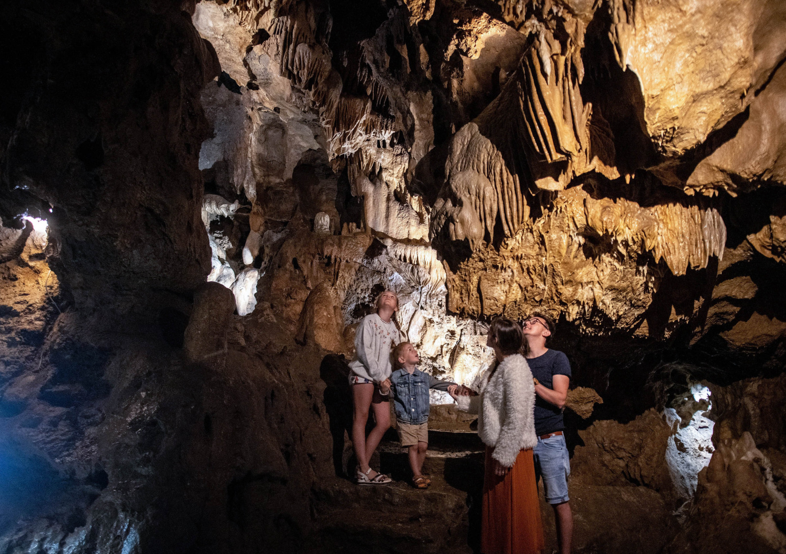 Familles à l'intérieur de la grotte observant les stalactites