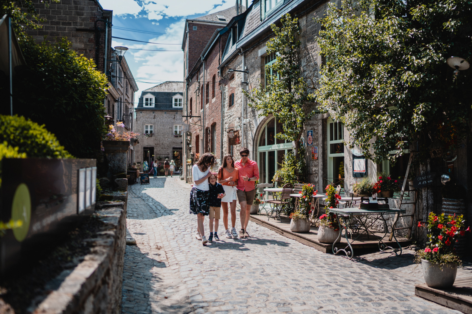 A family walks through the streets of Durbuy in summer