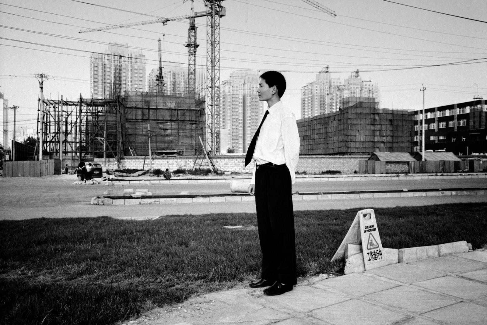 Homme chinois de profil devant des immeubles en construction