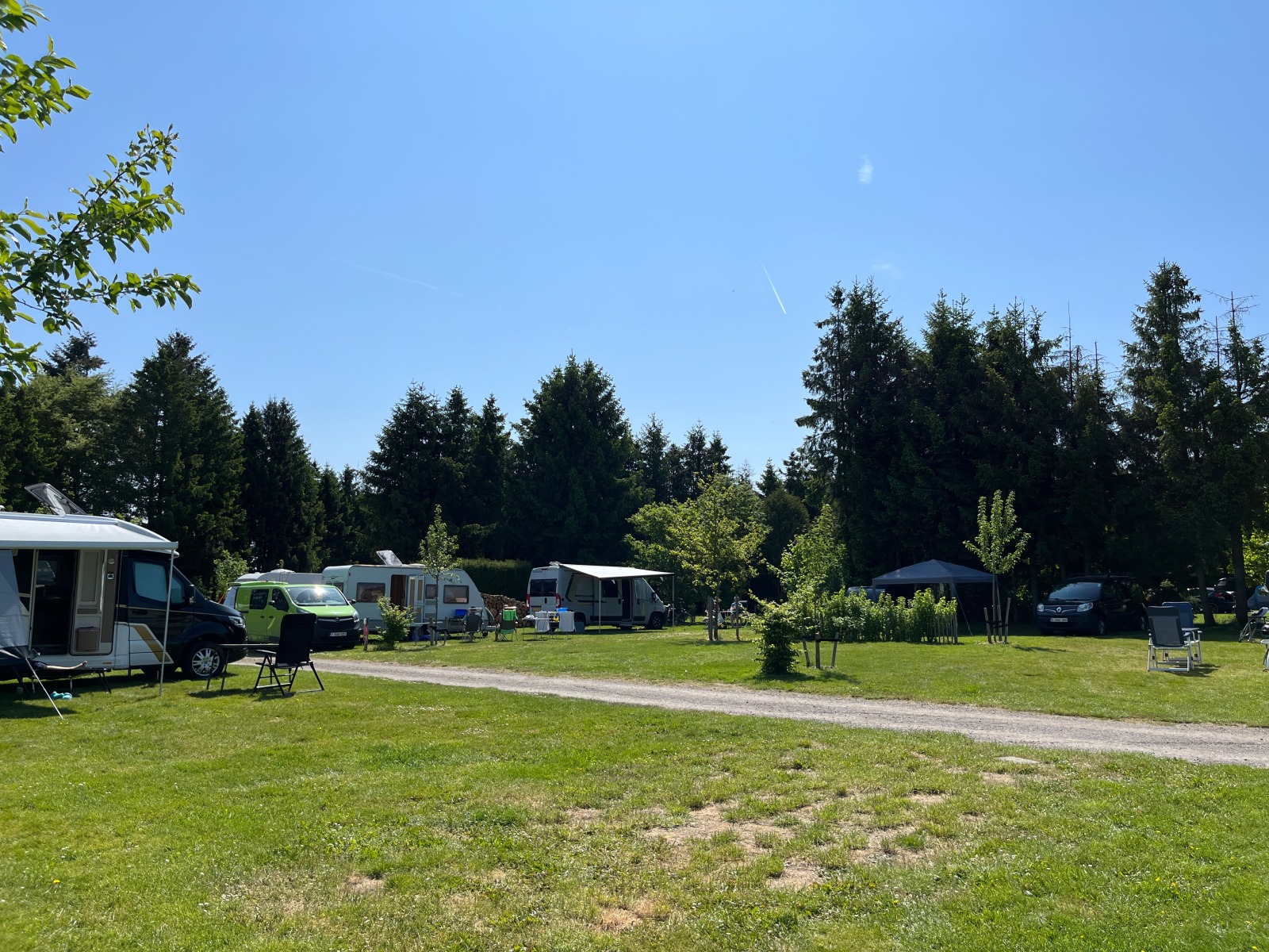 Several mobile homes parked in the middle of a meadow at the Au Bout du Monde campsite in Houffalize