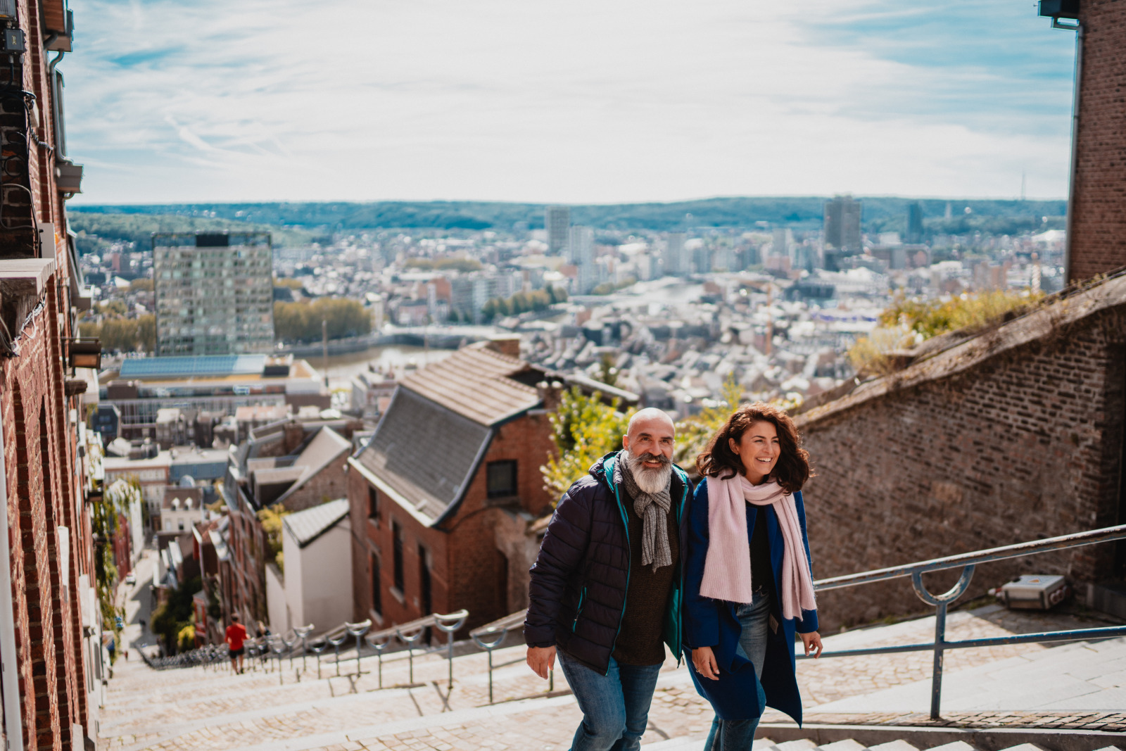 Un homme et une femme montent les marches de l'escalier de la montagne Bueren à Liège