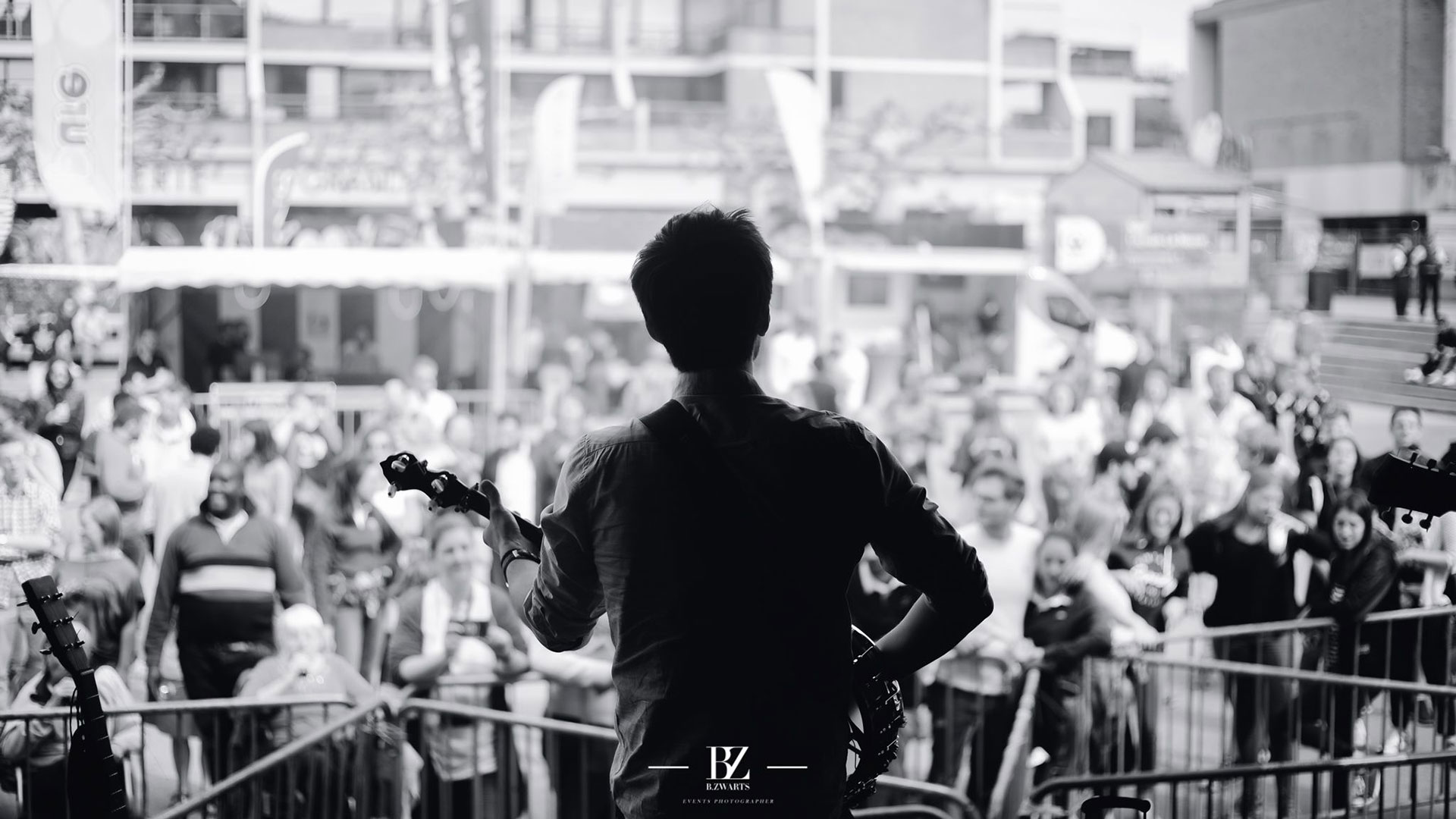 Black and white picture of a singer, his back to the crowd