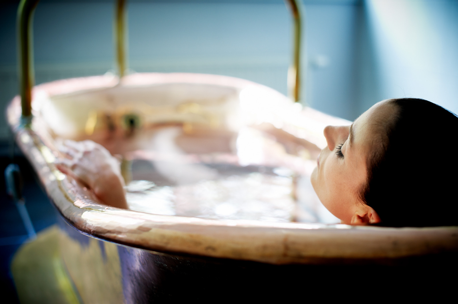 Woman taking a bath in a copper bathtub