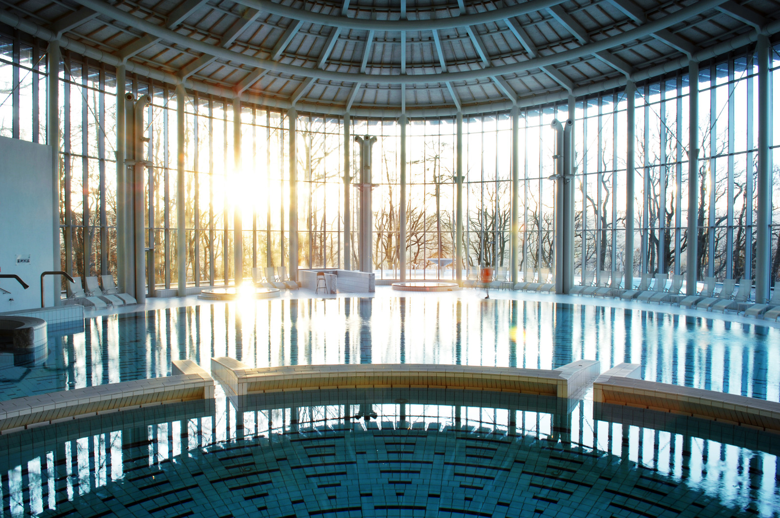 Indoor swimming pool lit by the setting sun