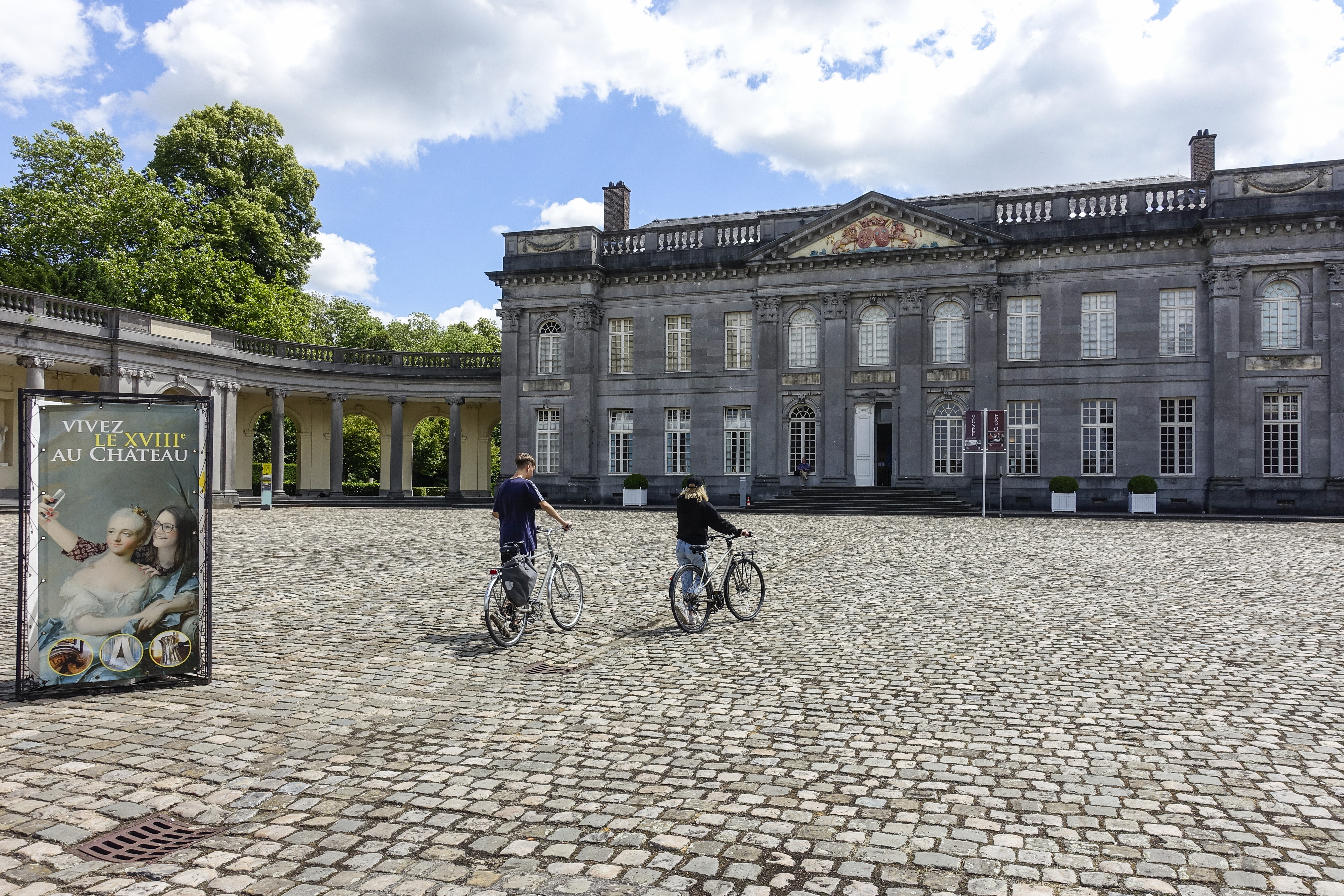 2 personnes à vélo devant le Château de Seneffe