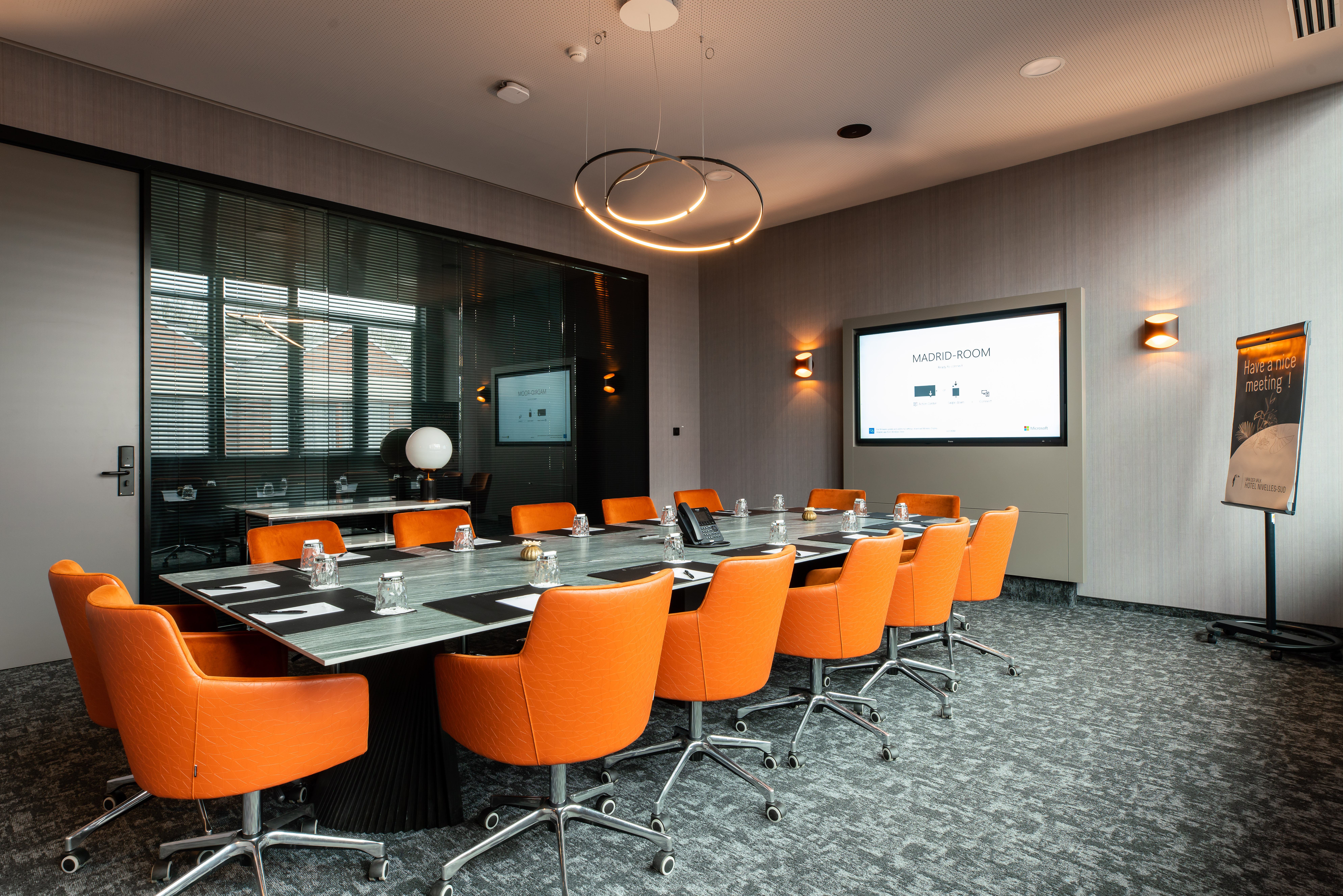 Salle de réunion avec chaises orange du Van der Valk Nivelles-Sud