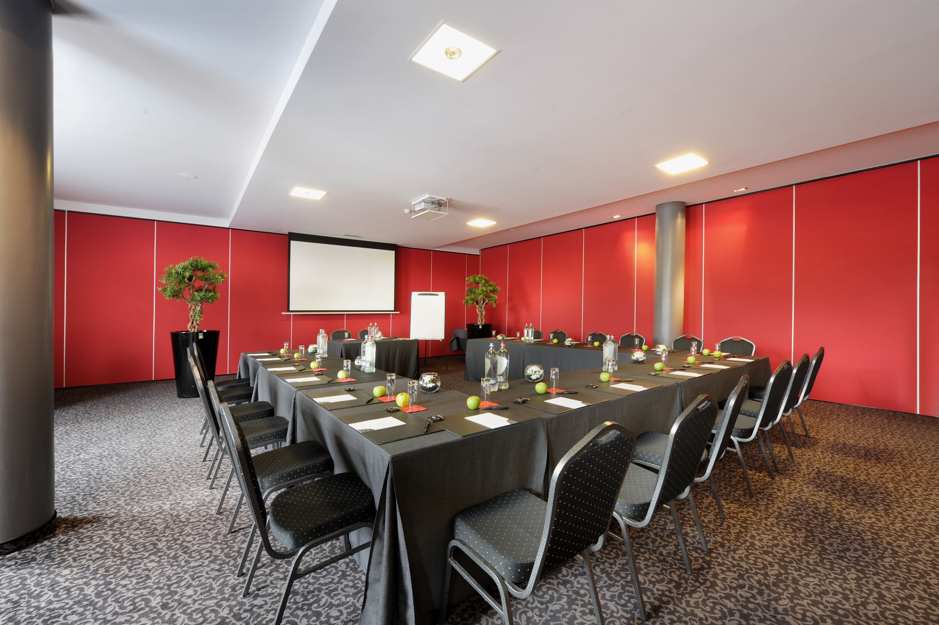 salle de réunion en Wallonie avec mur rouge et tables en U