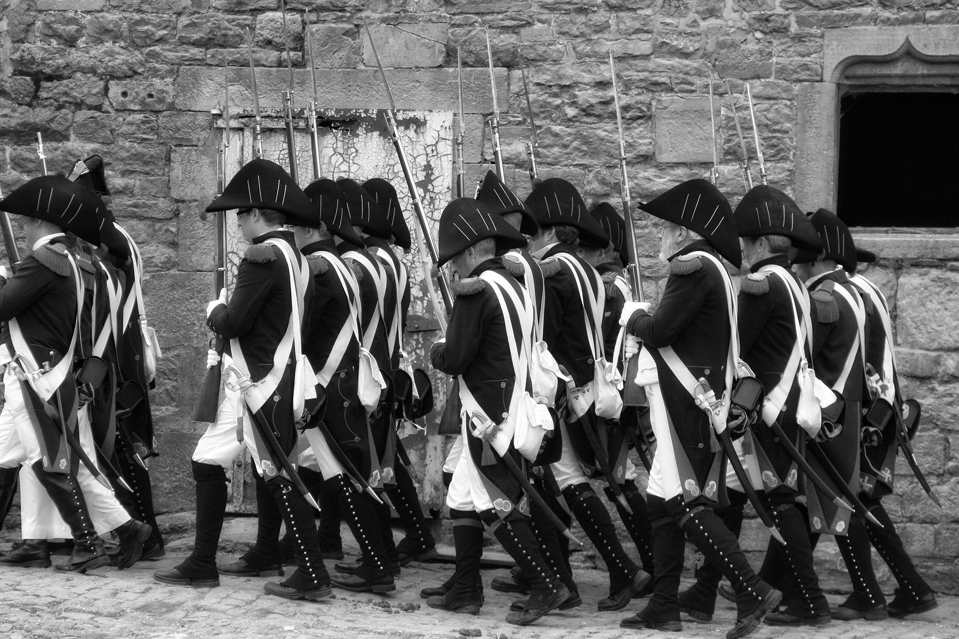 Soldats napoléoniens en rang défilant dans les rues d'un village