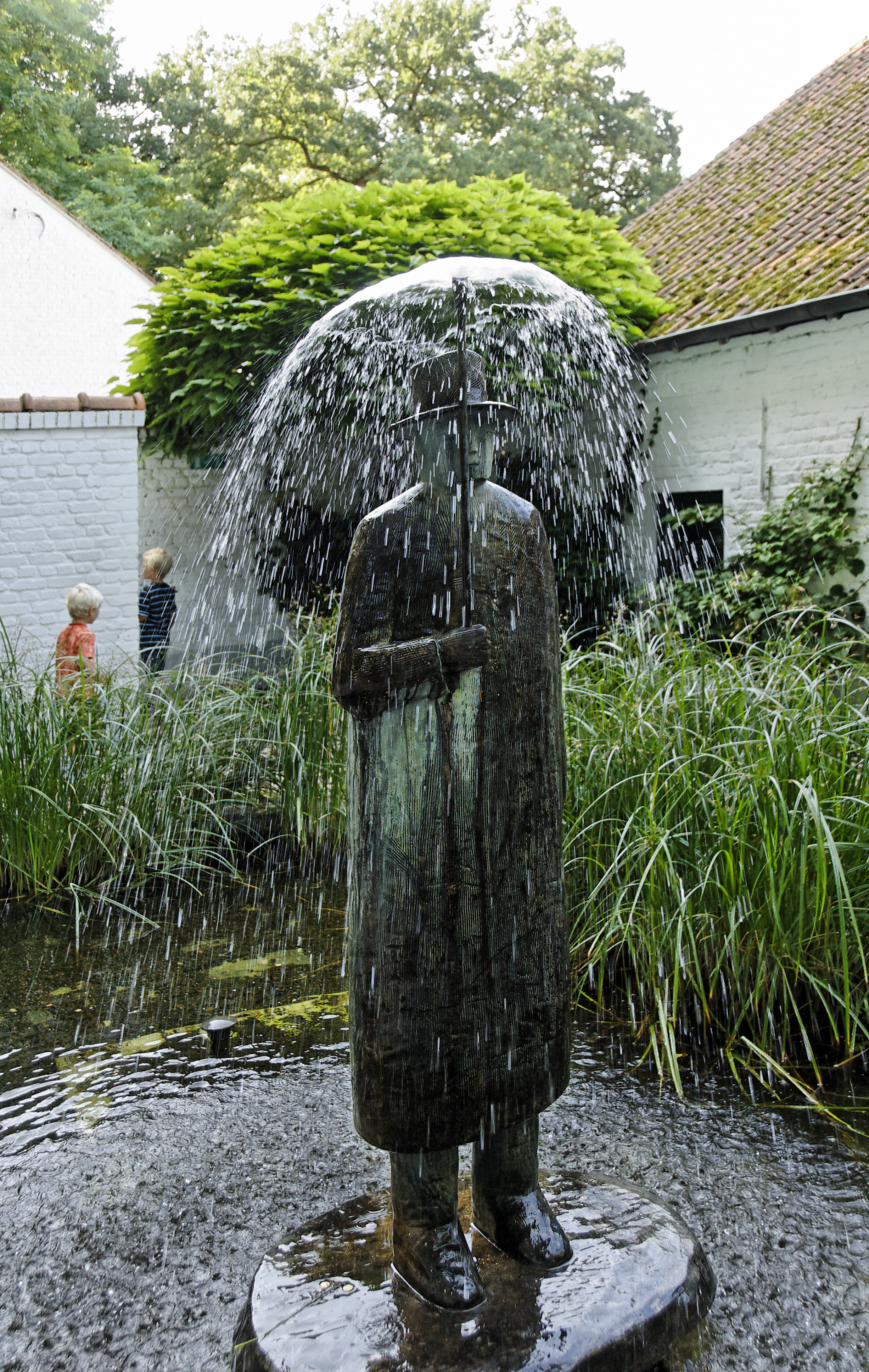 Fuente - Escultura Jean-Michel Folon con un paraguas y dos niños al fundo