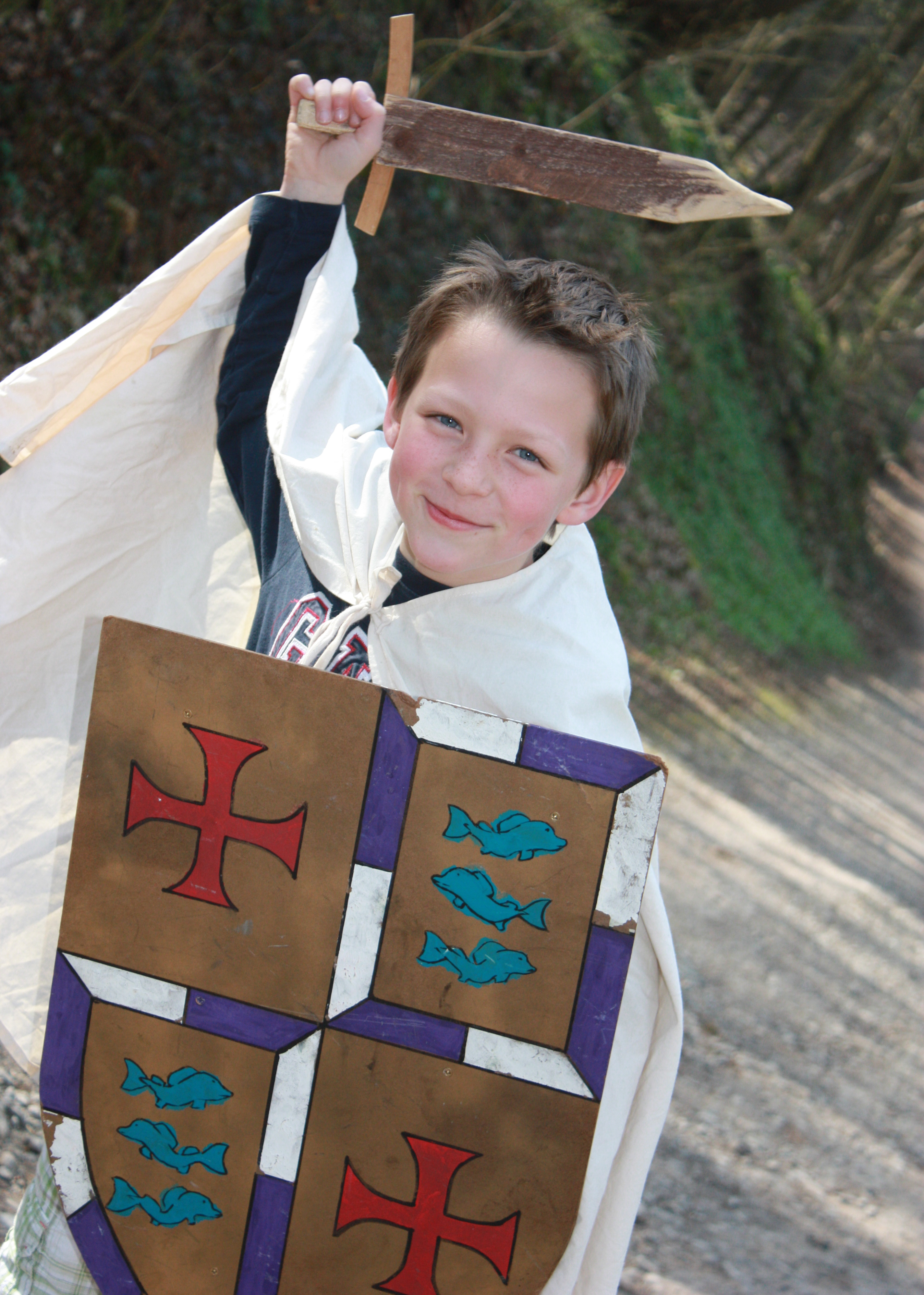 Jeune garçon déguisé en chevalier avec un bouclier et une épée au Domaine de Palogne