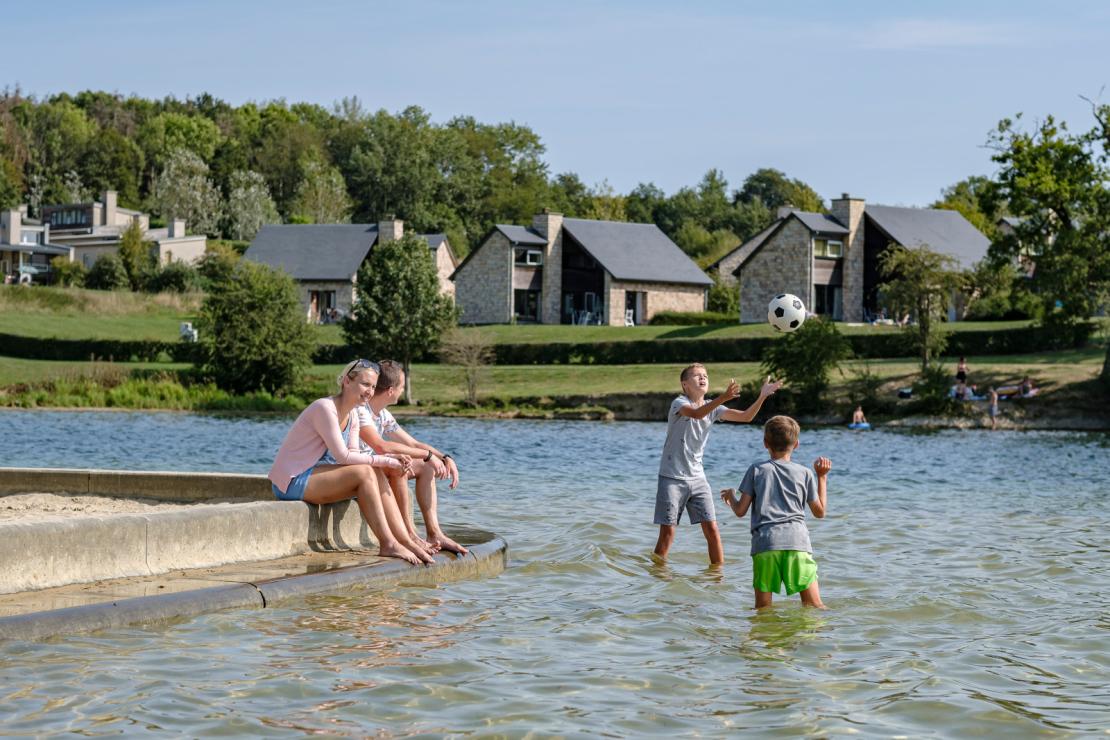 Famille qui s'amuse dans la zone de baignade du Village de vacances aux Lacs de l'Eau d'Heure