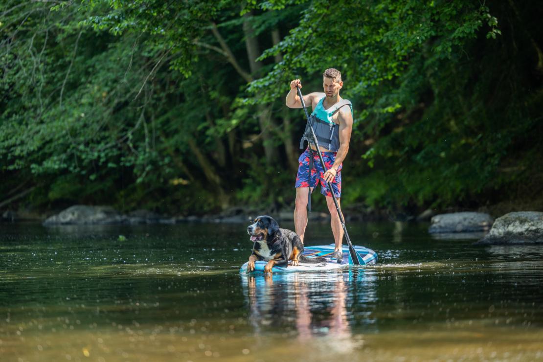 Homme avec son chien sur un paddle