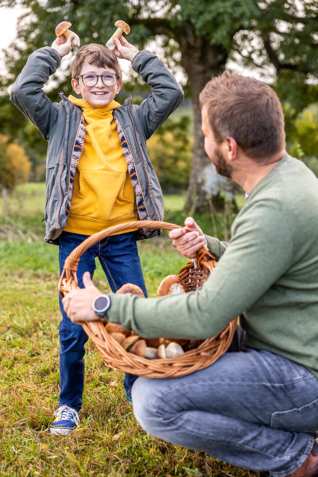 Une enfant s'amuse avec des champignons ramassés en famille en automne