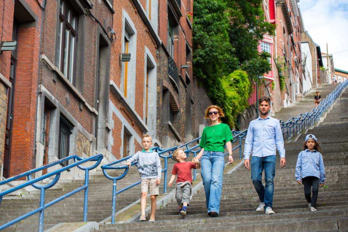 Une famille descend les escaliers de la montagne de Bueren à Liège