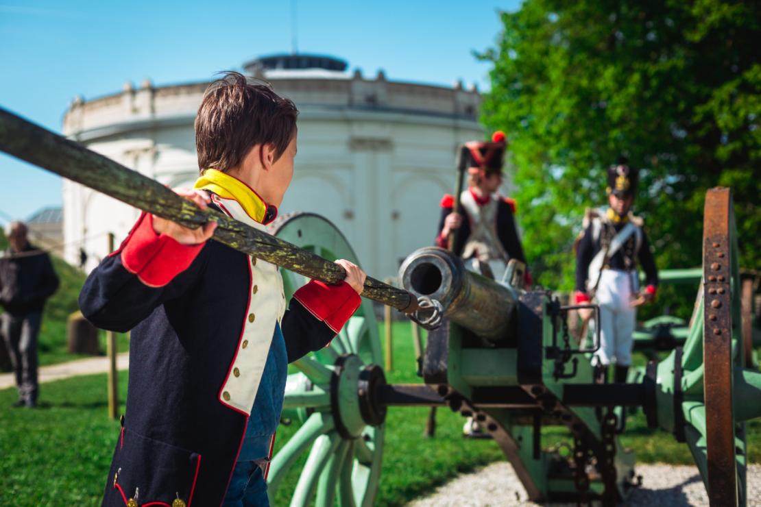Un enfant habillé en soldat napoléonien charge un canon lors de la reconstitution de la Bataille de Waterloo