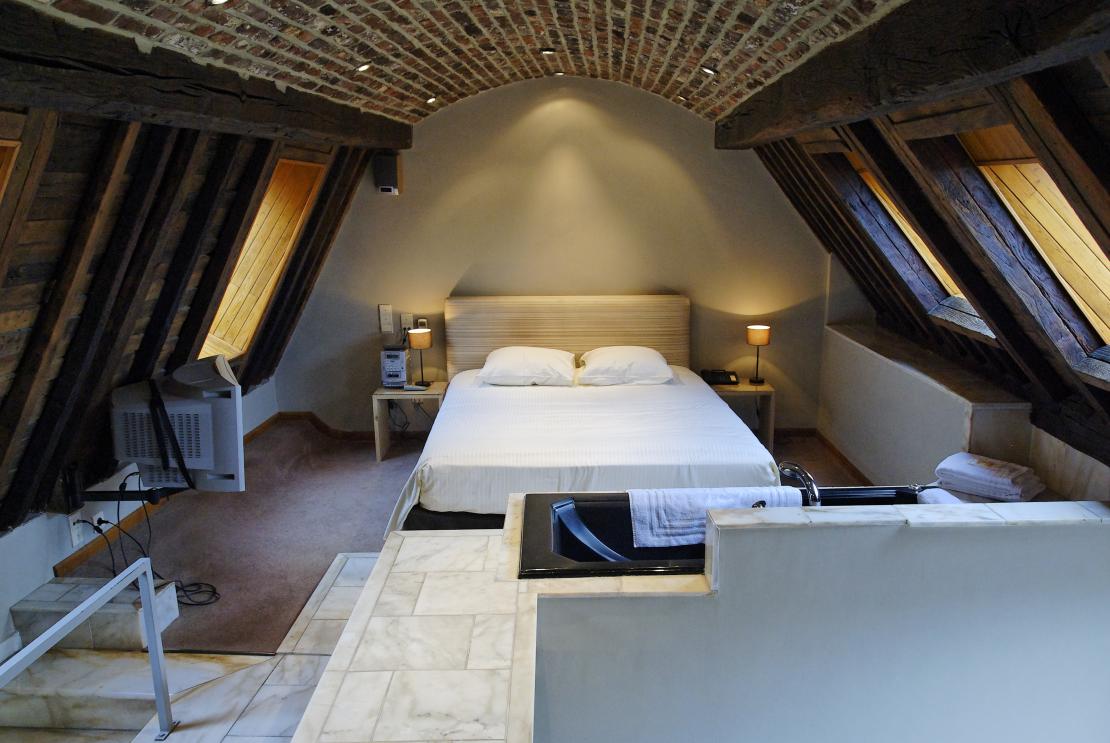 Hotel room with wooden walls and a double bed in the hotel Les Tanneurs in Namur
