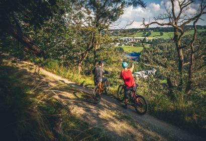 Two mountain bikers enjoy a beak on the heights of the trail center in Spa