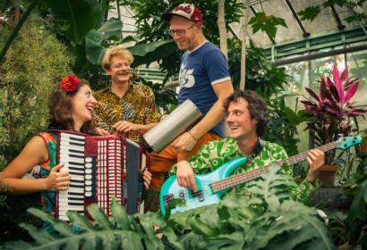 Vier muzikanten in een plantenrijke serre