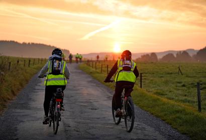 Cyclistes traversant la campagne lors d'un coucher de soleil