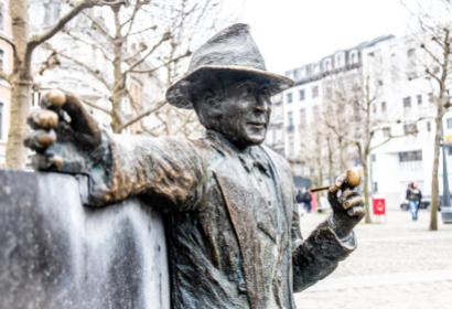 Photographie au format portrait de la statue de Georges Simenon située à Liège sur la Place Saint-Lambert
