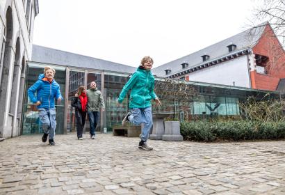 Des enfants courent dans la cour du musée Grand Curtius avec leurs parents derrière