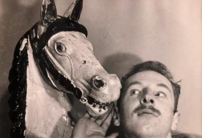 Photo portrait de Jean-Marie van Espen placé à côté d'un cheval en bois