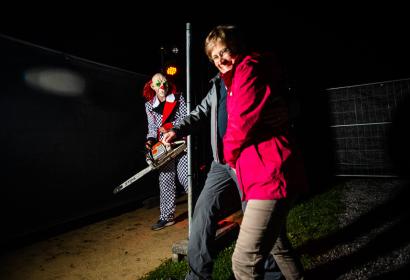 Couple walking in the dark and attacked by a clown, chainsaw in hand
